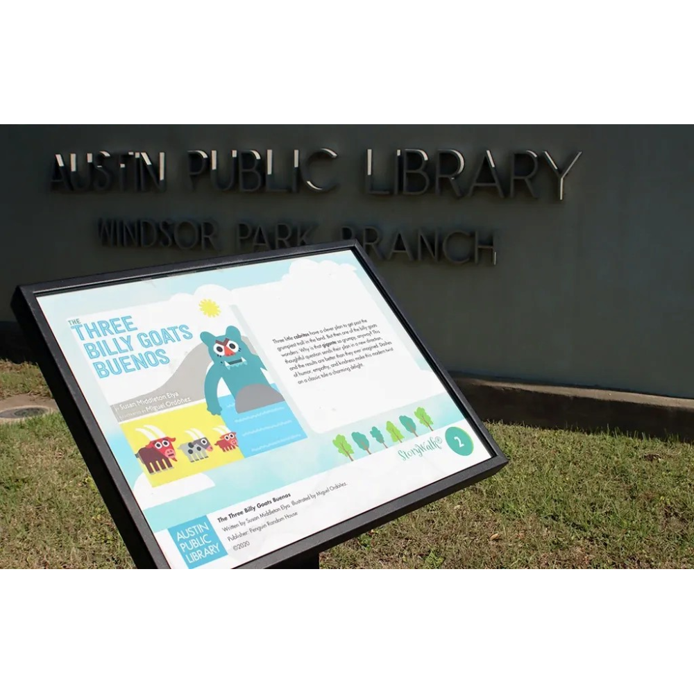 A sign with a page from a picture book outside at a library