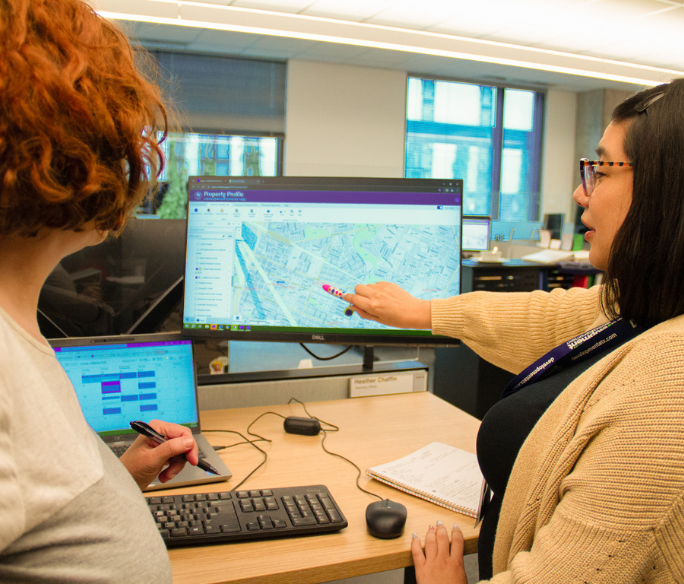 Two people looking at a map on a computer screen