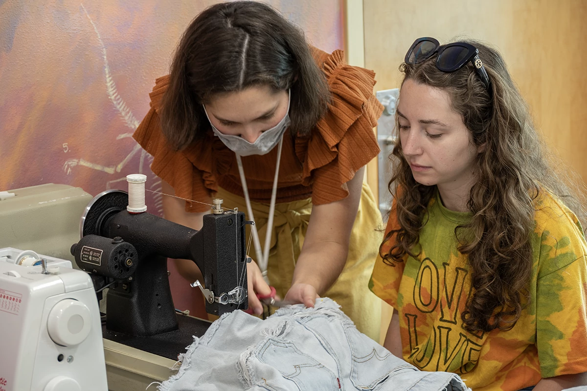 A Fix-It volunteer helps to repair damaged clothing.