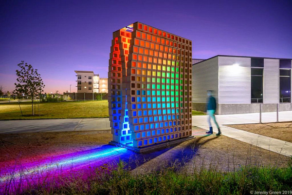 A public art installation with colorful lights at night
