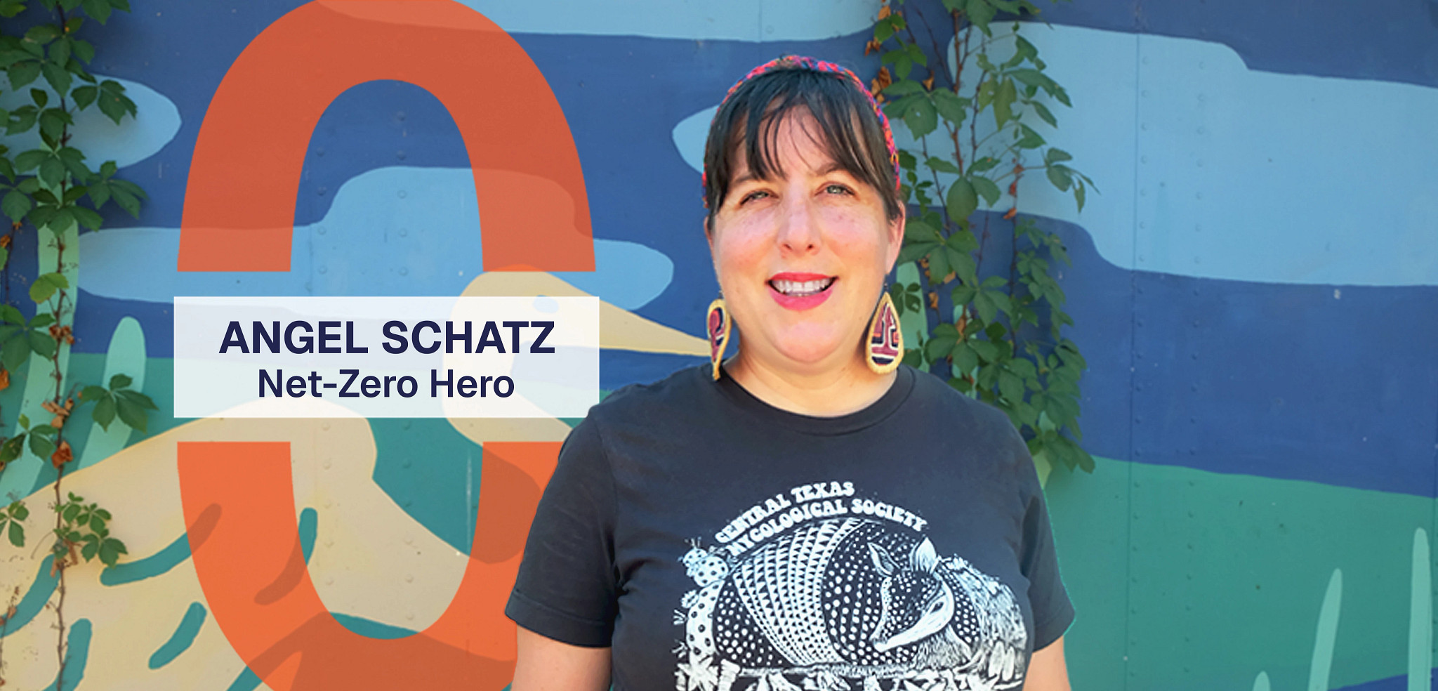 Angel Schatz smiles in front of a mural at Circle Acres Preserve. A graphic reads, Angel Schatz, Net-Zero Hero.