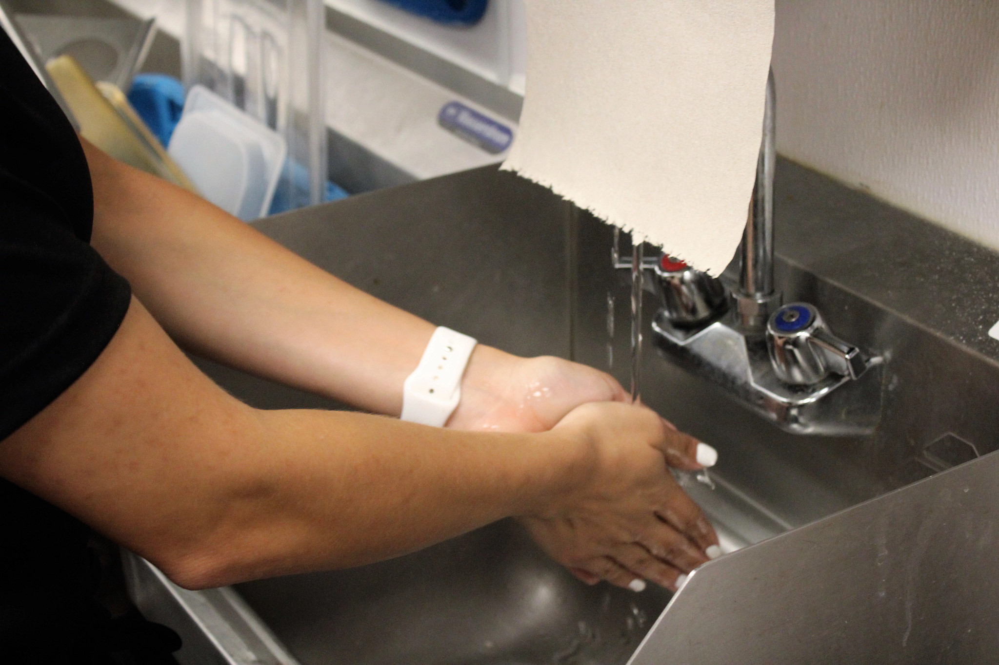 Health Inspector washes hands in a sink