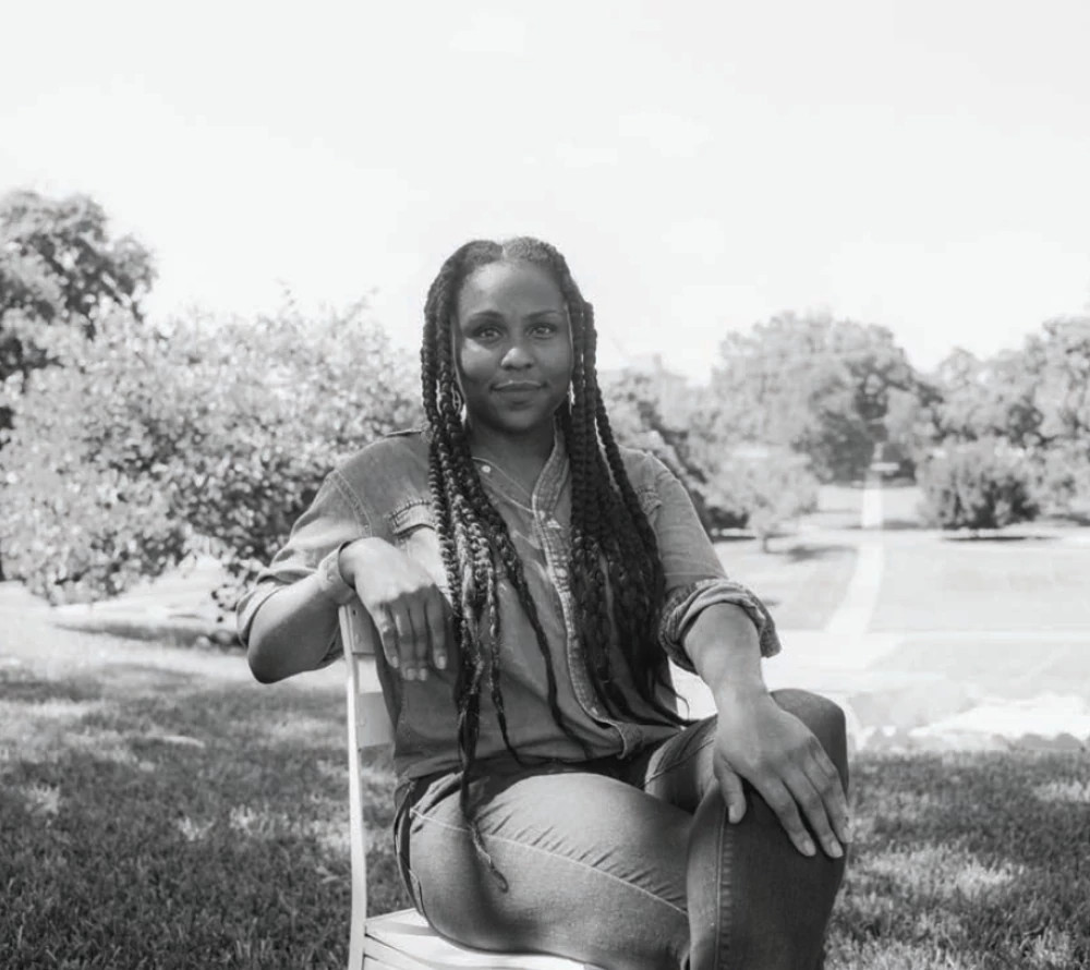 A black and white photo of a woman sitting in a chair.