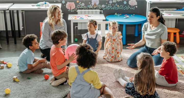 students gather around two day care teachers