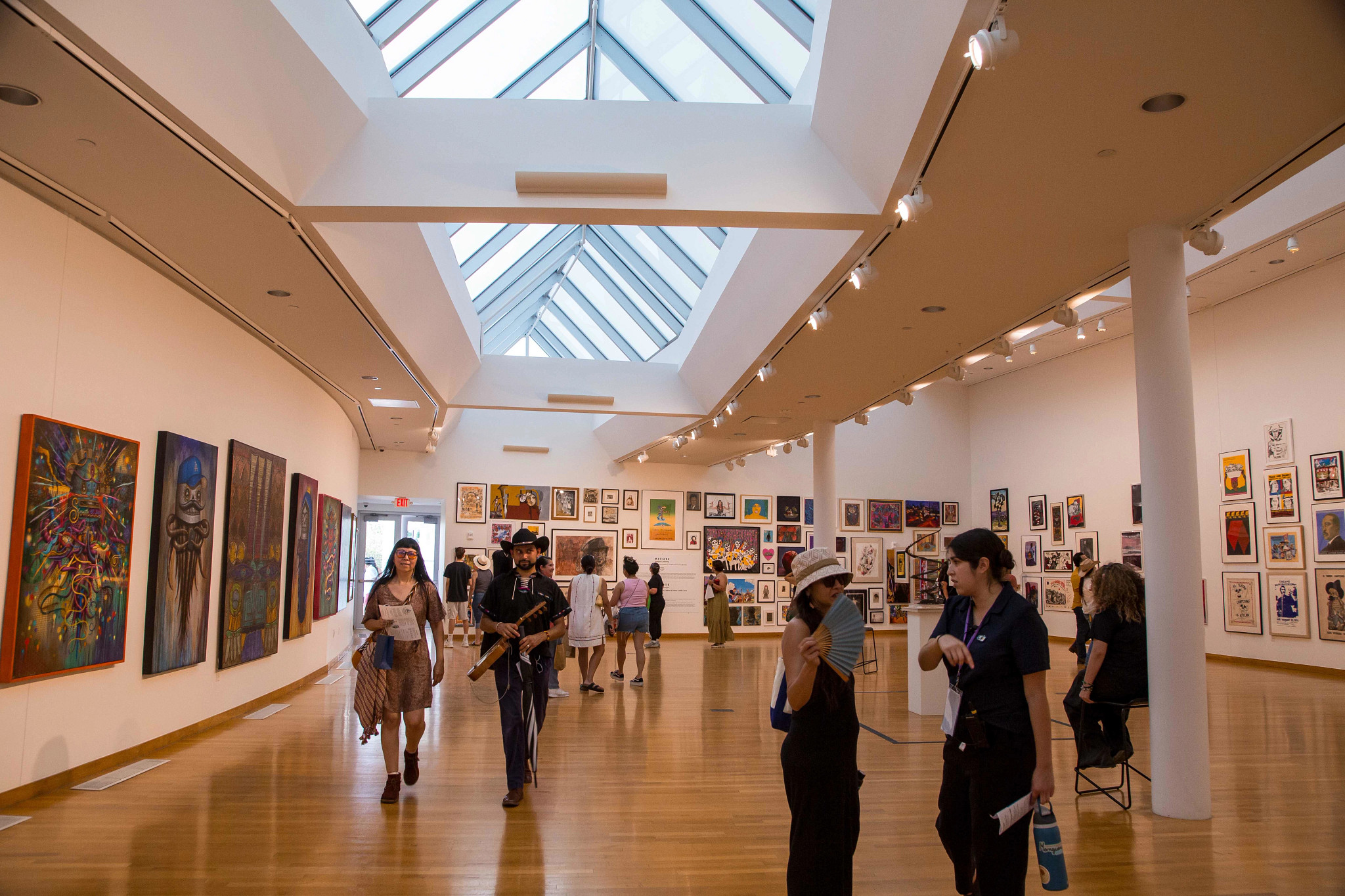 People walking around in a bustling art gallery