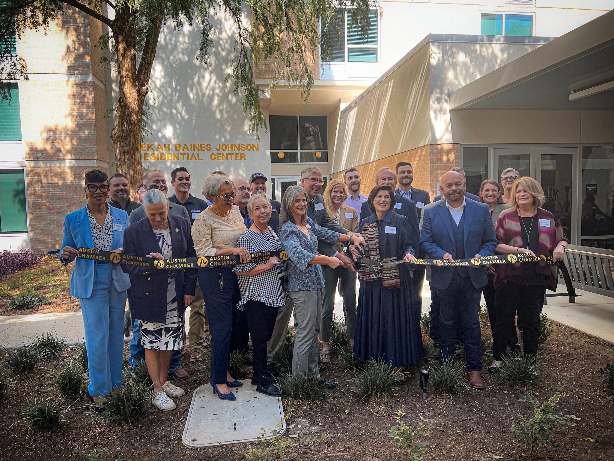 City and community leaders participate in a ribbon-cutting ceremony at the Rebekah Baines Johnson Residential Center grand reopening.