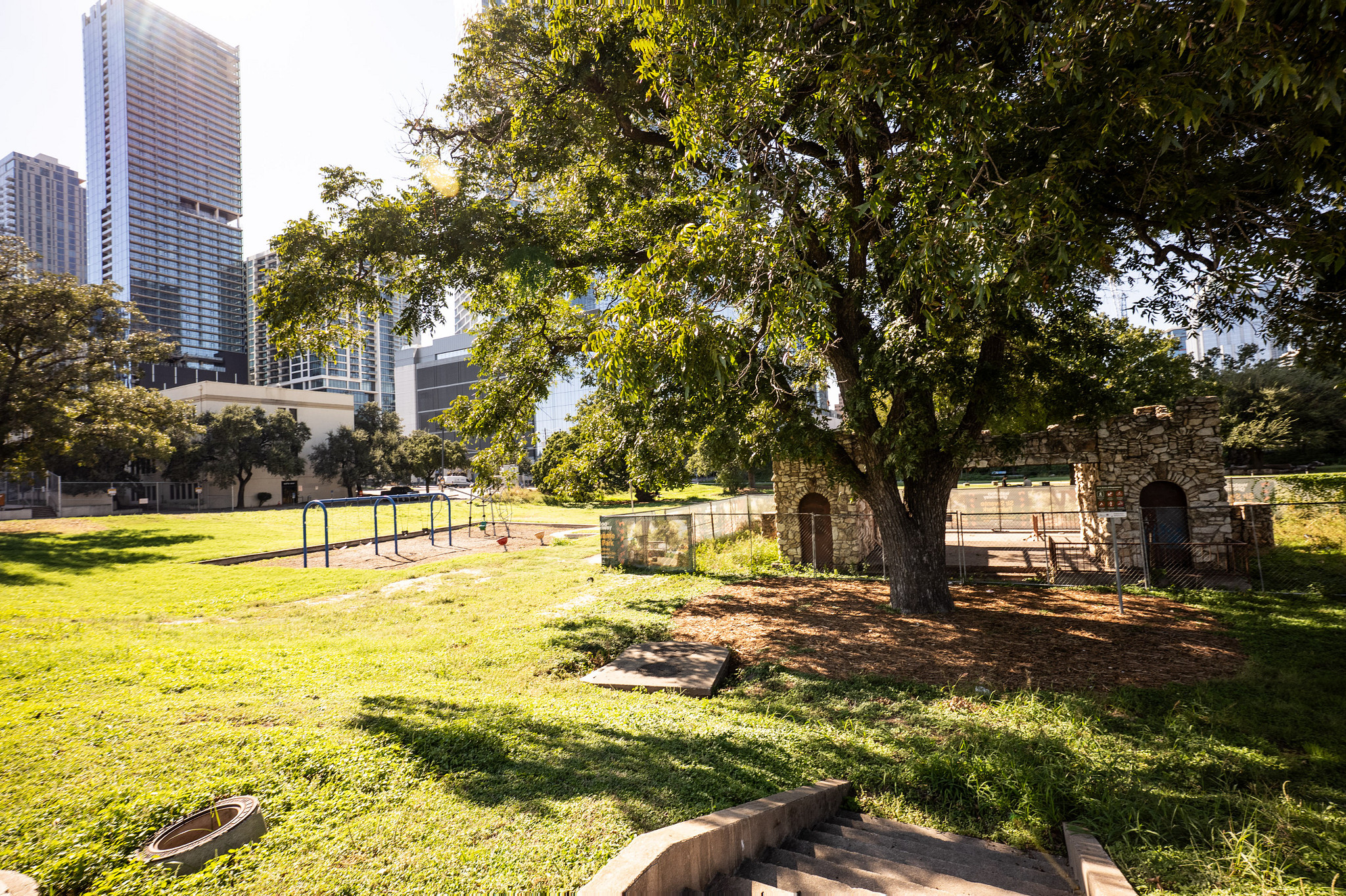 The historic shelter house, swing set, entry stairs and shade tree at Sir Swante Palm Park in 2026.
