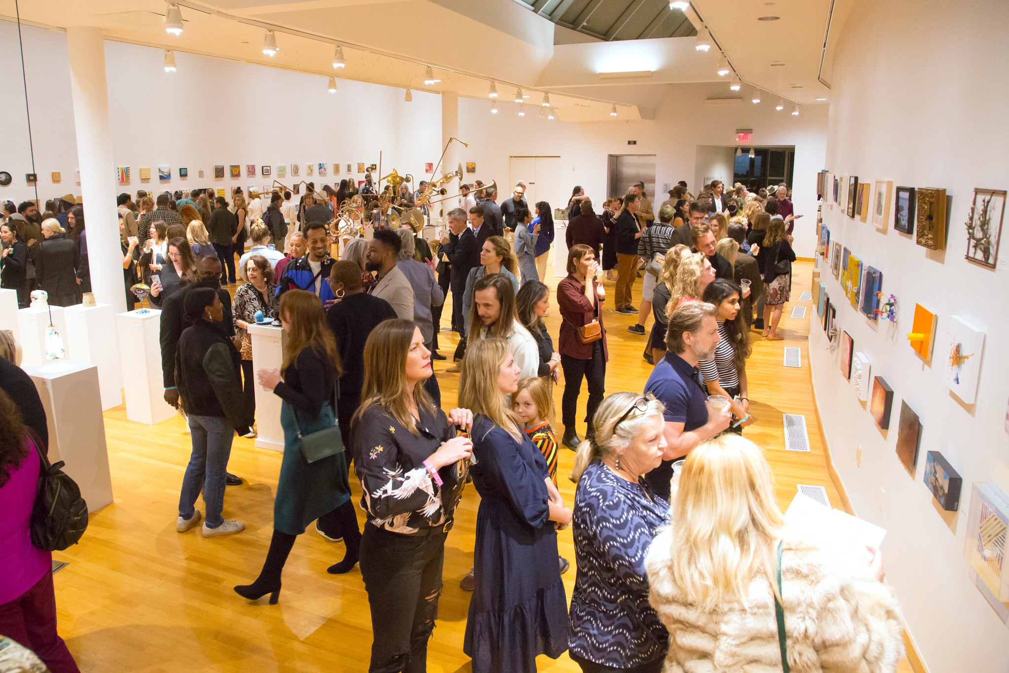 Crowd of people in a bustling gallery space