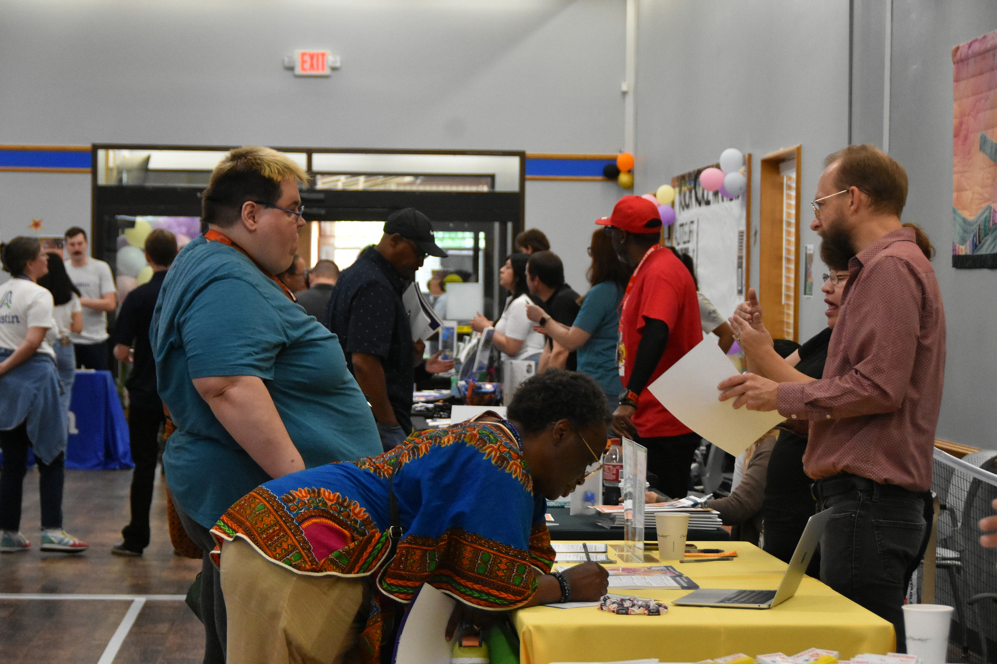Austin community members, City of Austin staff from Austin Housing and Austin Planning, and resource providers gathering together in a rec center for a Housing Affordability Fair