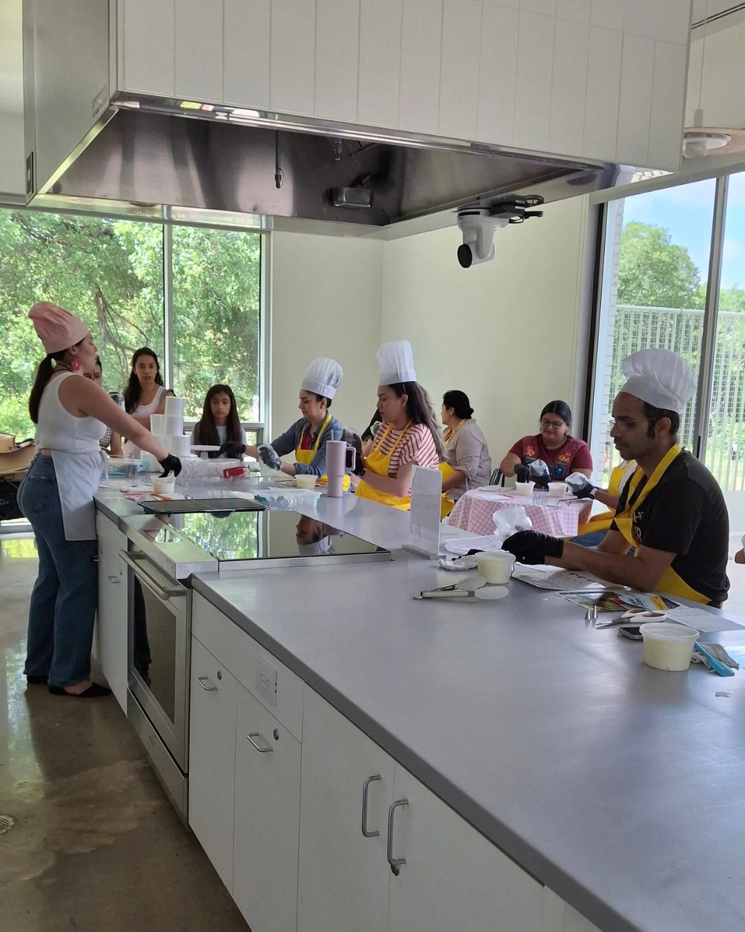 People baking desserts in a teaching kitchen with an instructor