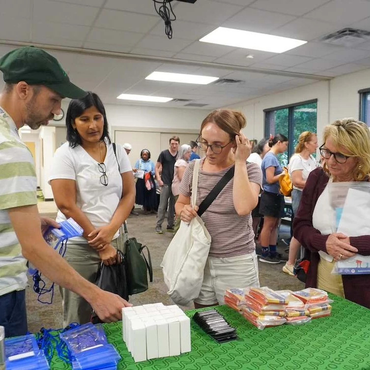 Event participants looking at emergency preparedness supplies at a booth.
