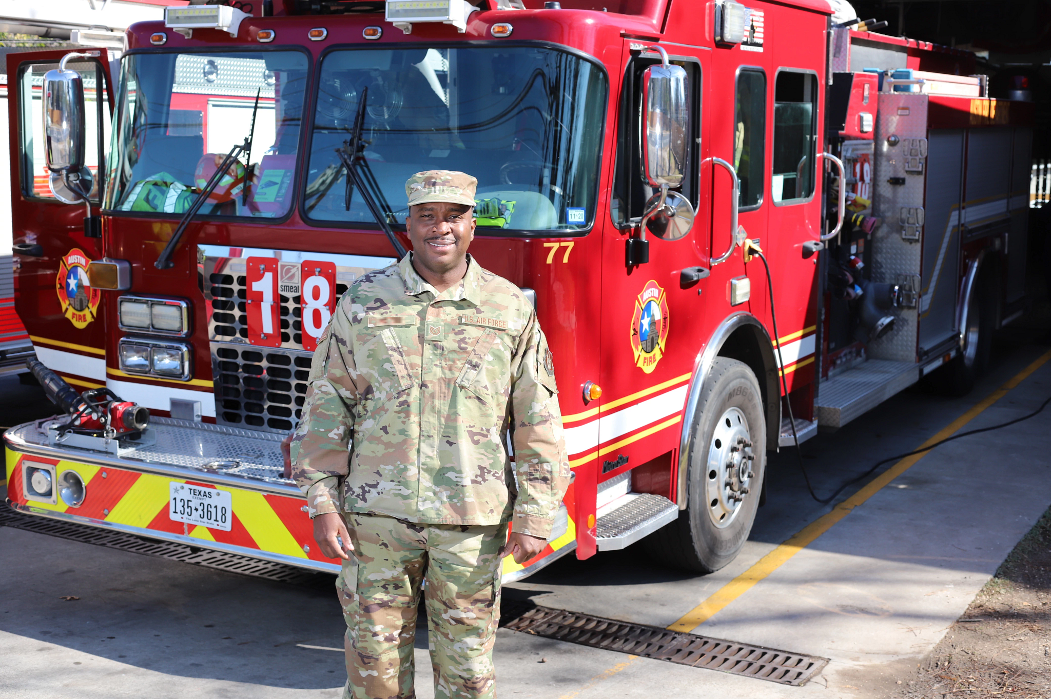 A United States Military veteran smiling in uniform in front of an Austin Fire truck