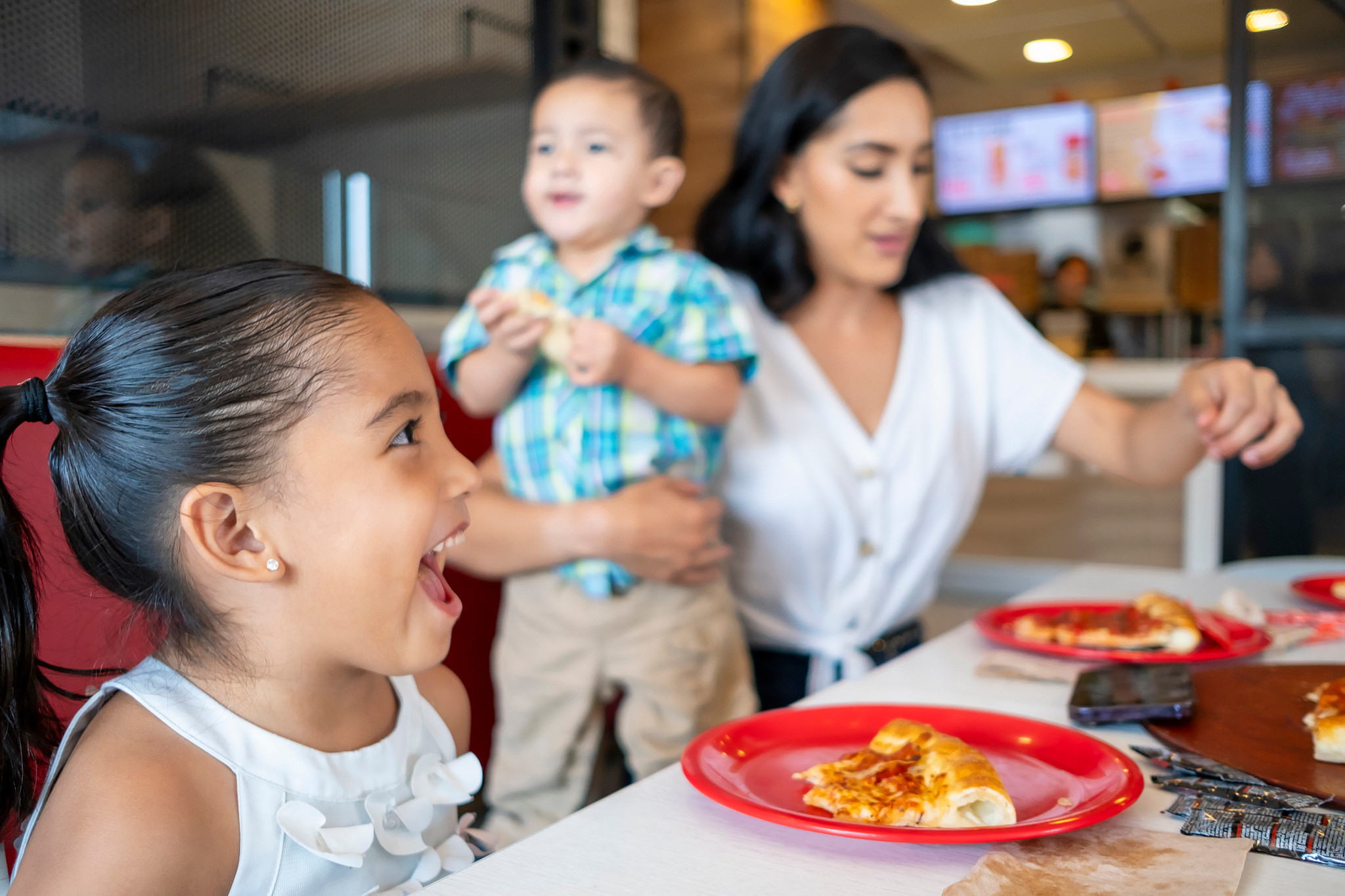 Excited family eating pizza in a food court