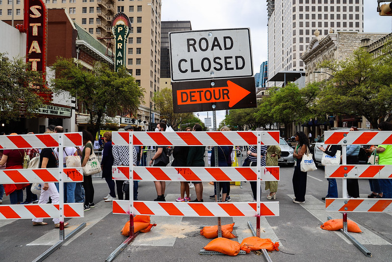 A picture of a street in downtown Austin blocked off by a barricade with a signs that read 'Road Closed' and 'Detour.'