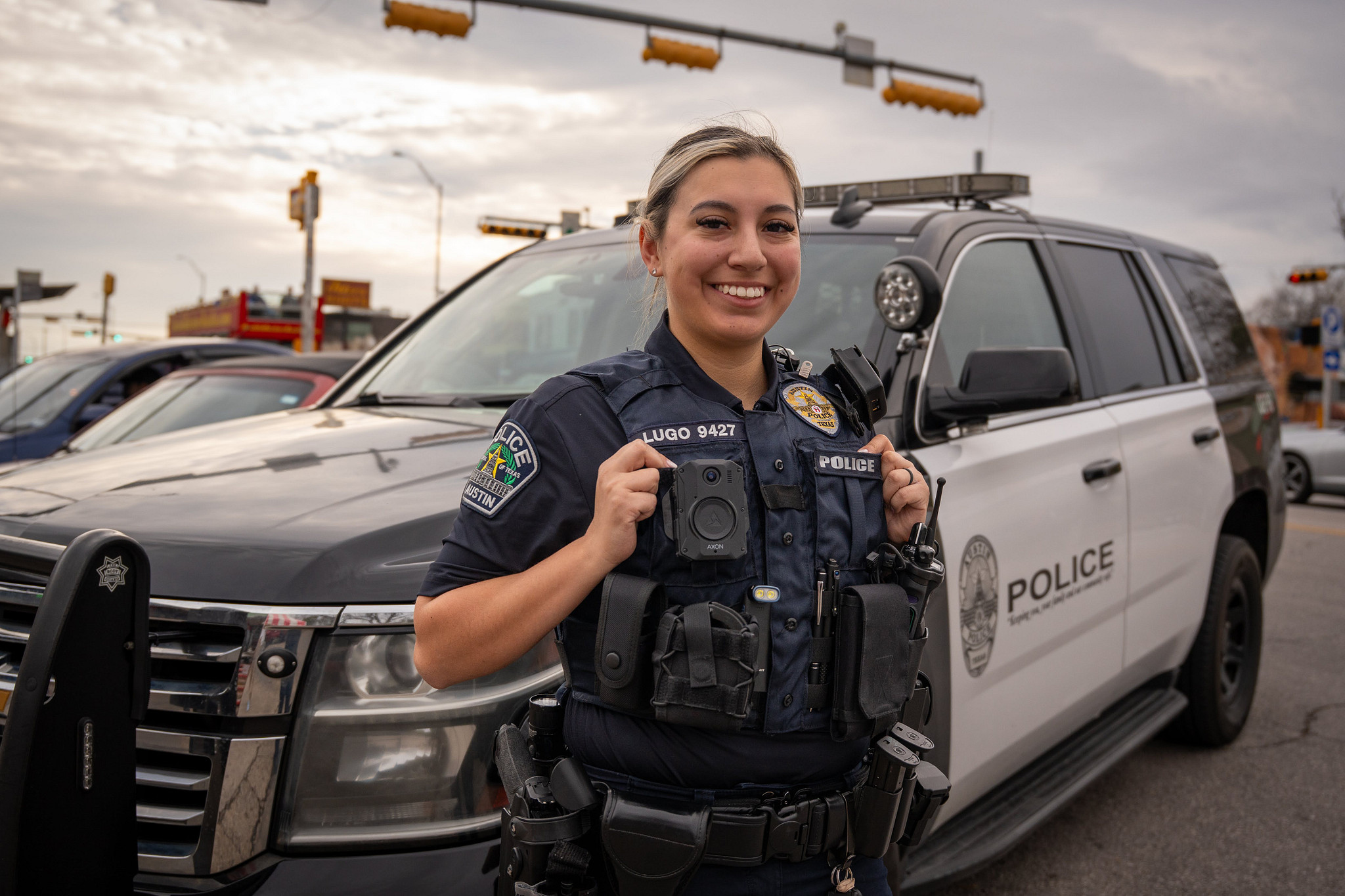 An Austin Police Officer standing in front of a police vehicle.