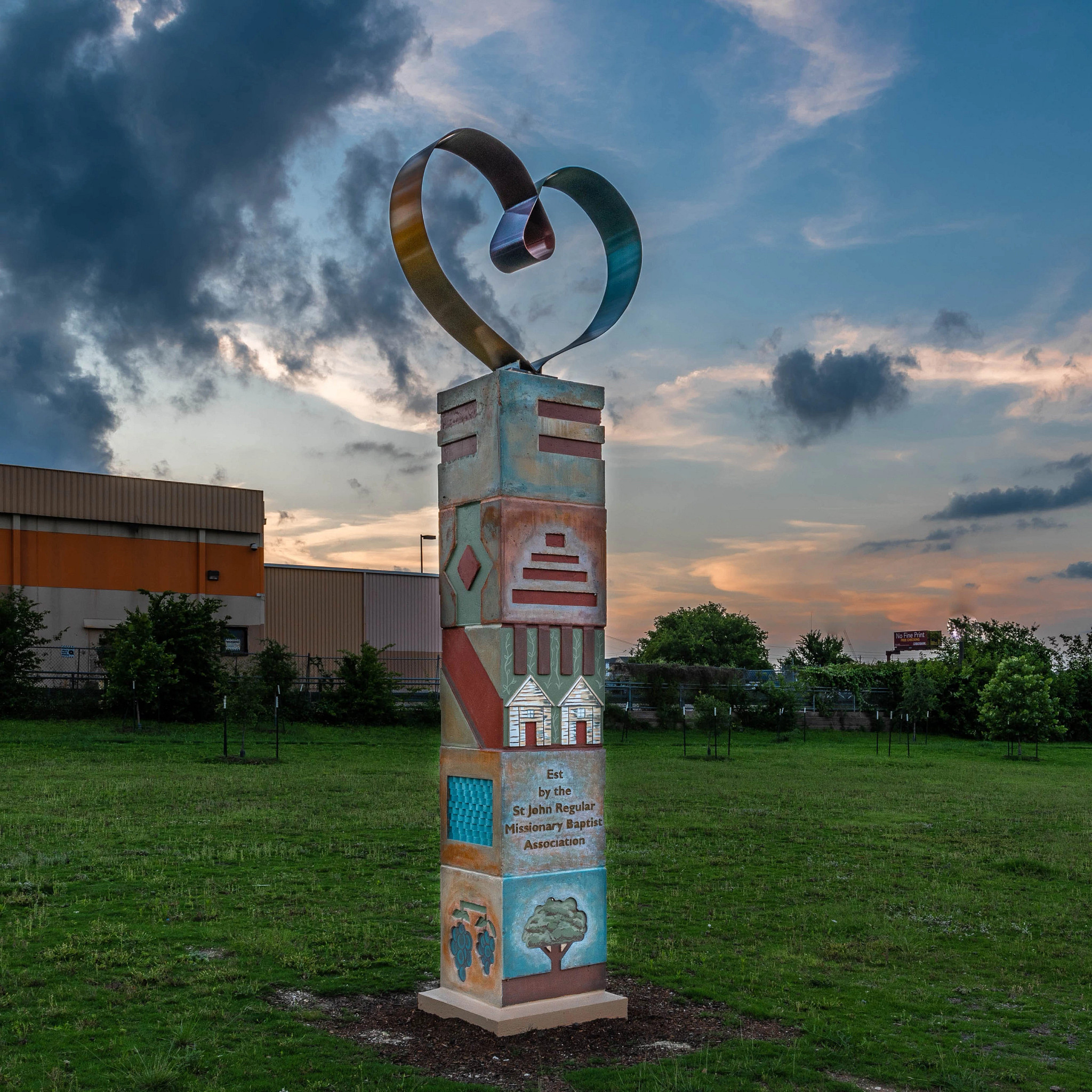 Public artwork, the St. John Pillar in the St. John Pocket Park at dusk under a cloudy sky.