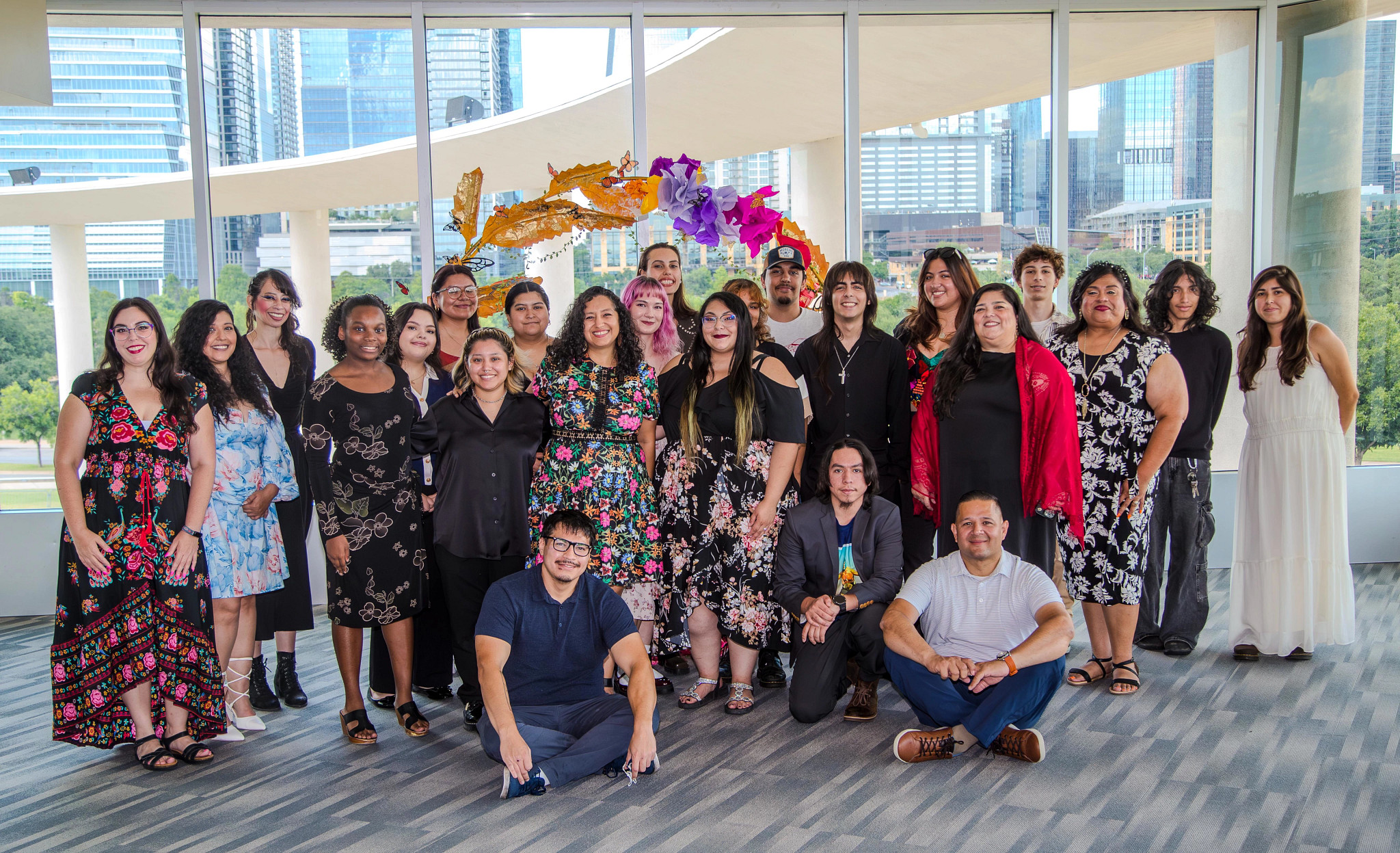 A group of people standing in front of a large decorative backdrop after a celebration