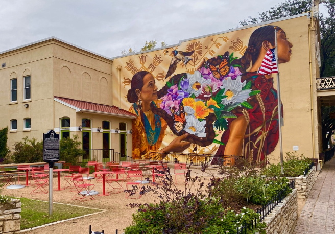 Mural behind park with red tables