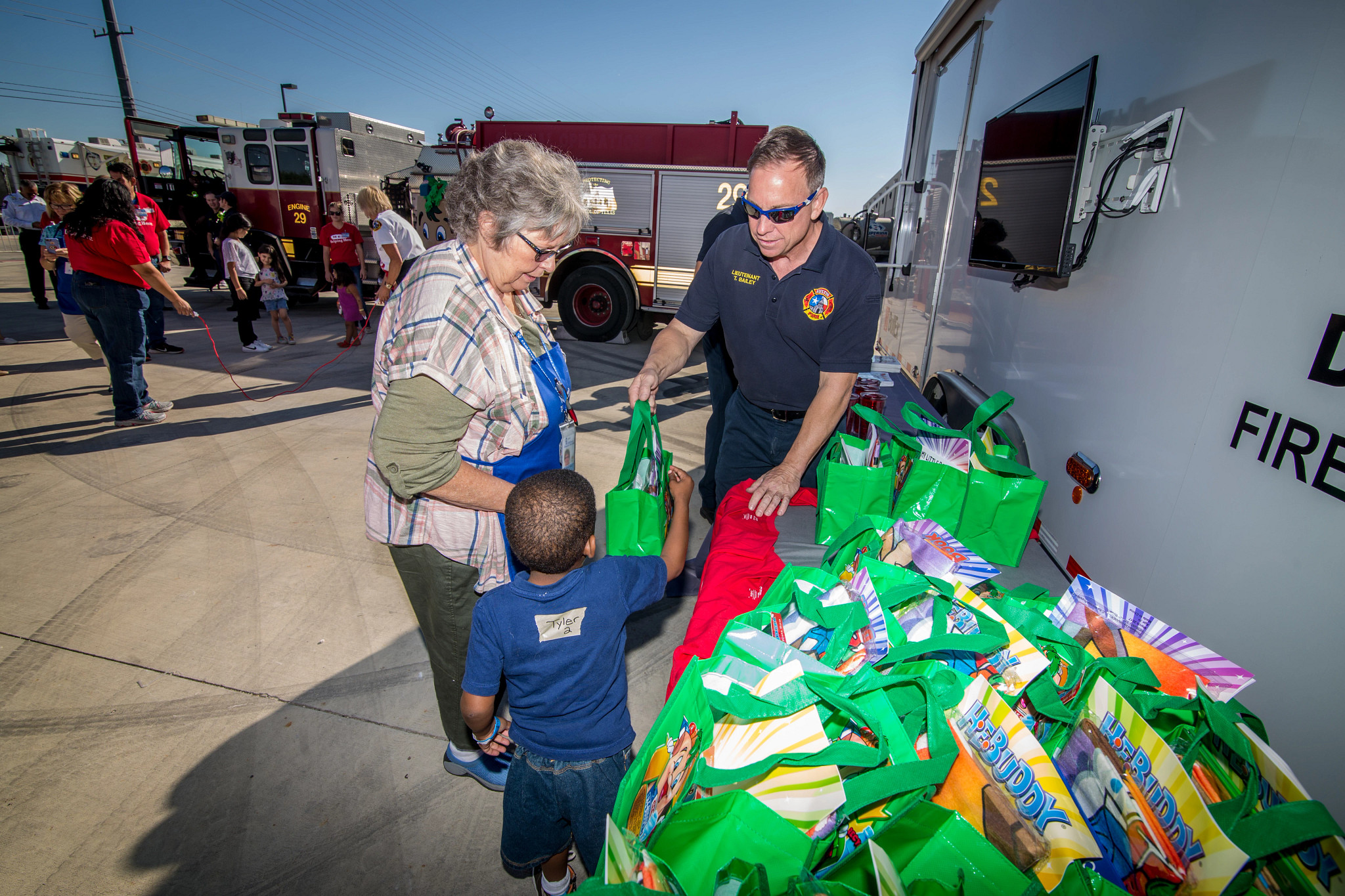 An AFD employee handing bags to a child and adult civilian