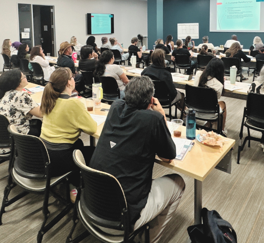 individuals sitting in a classroom watching a presentation