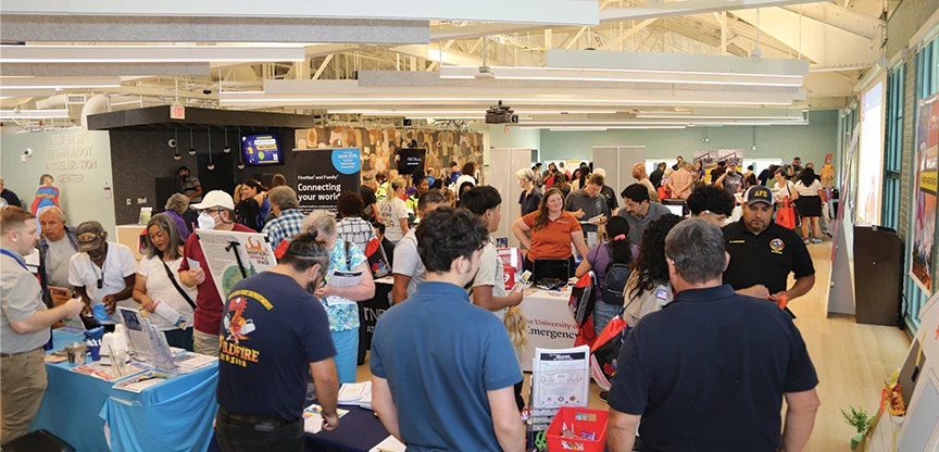 A crowd of people look at vendor booths at a previous emergency preparedness fair