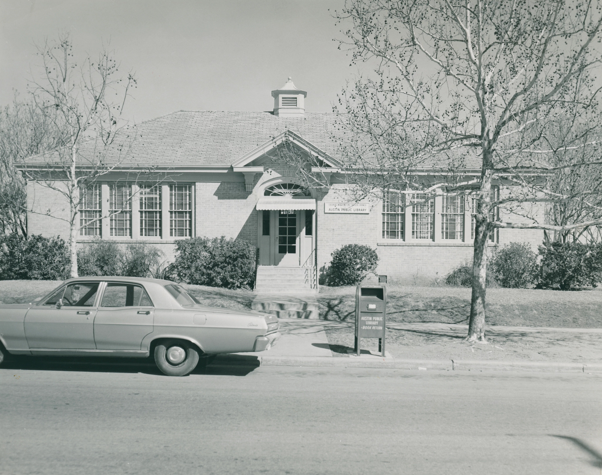 Black and white photo of the Carver Genealogy Center with car parked in front