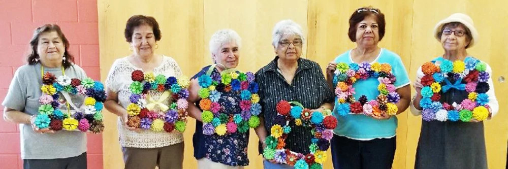 Seniors posing with frames they made out of flowers