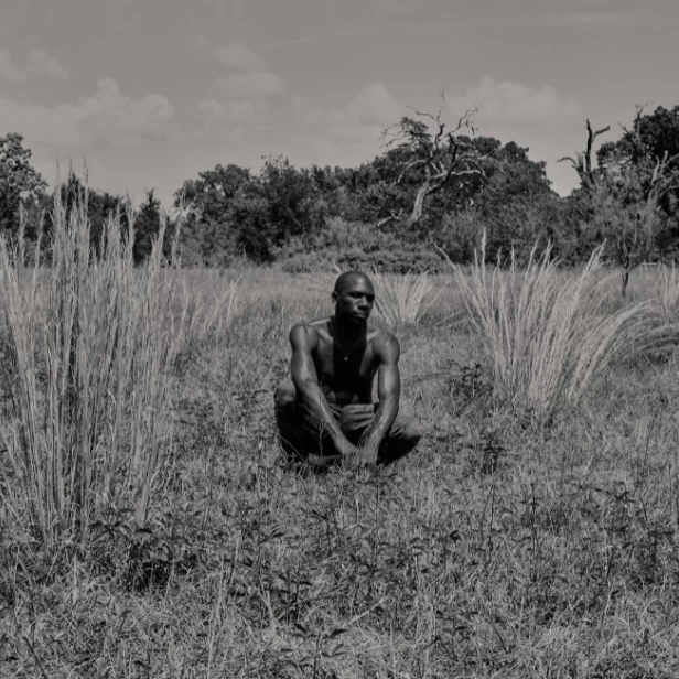portrait photo of artist hakeem adewumi in a field