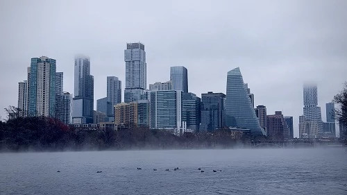 The downtown Austin skyline viewed from Lady Bird Lake with fog coming off the water